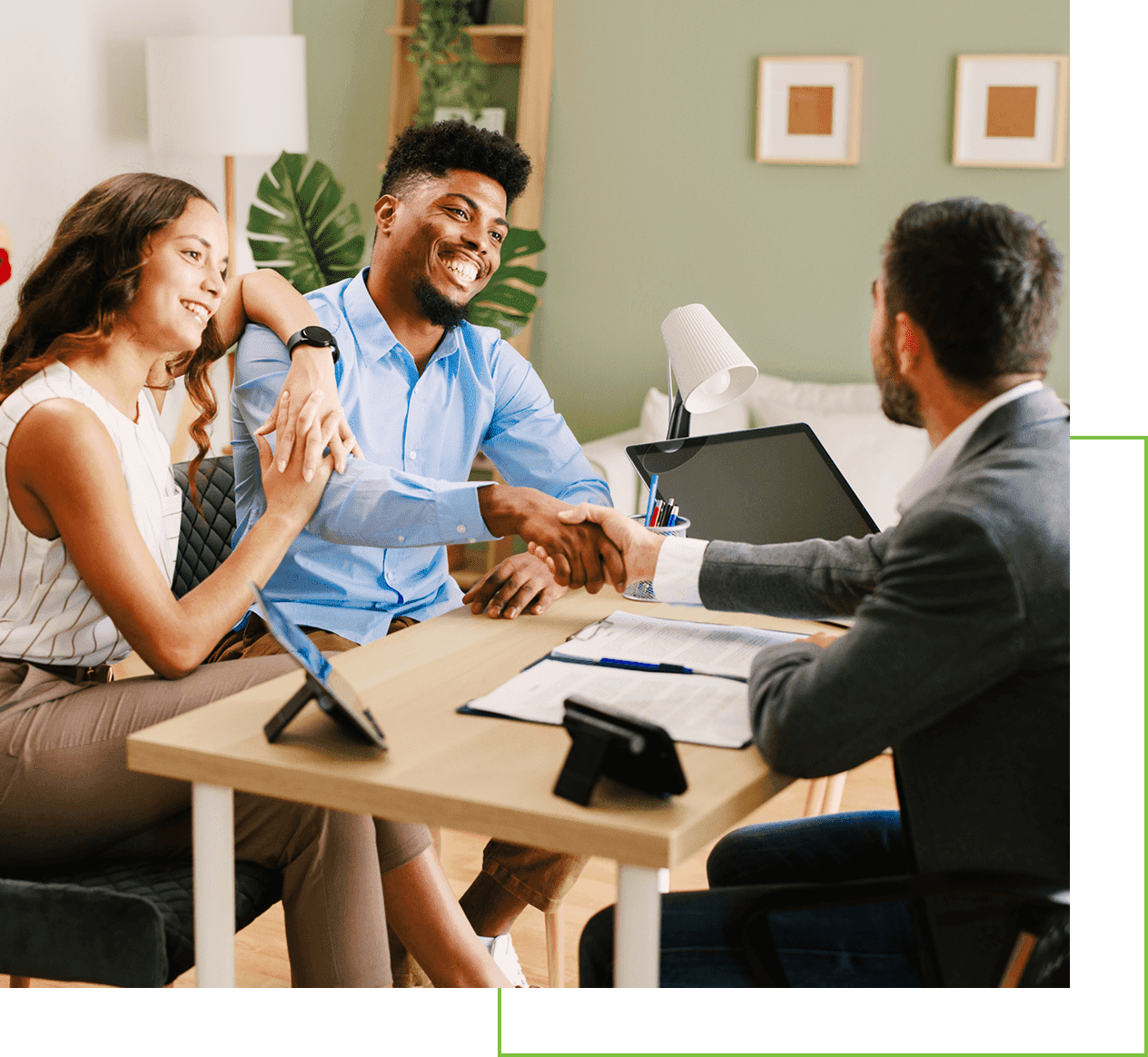 Couple happily shaking hands with a professional at a meeting.