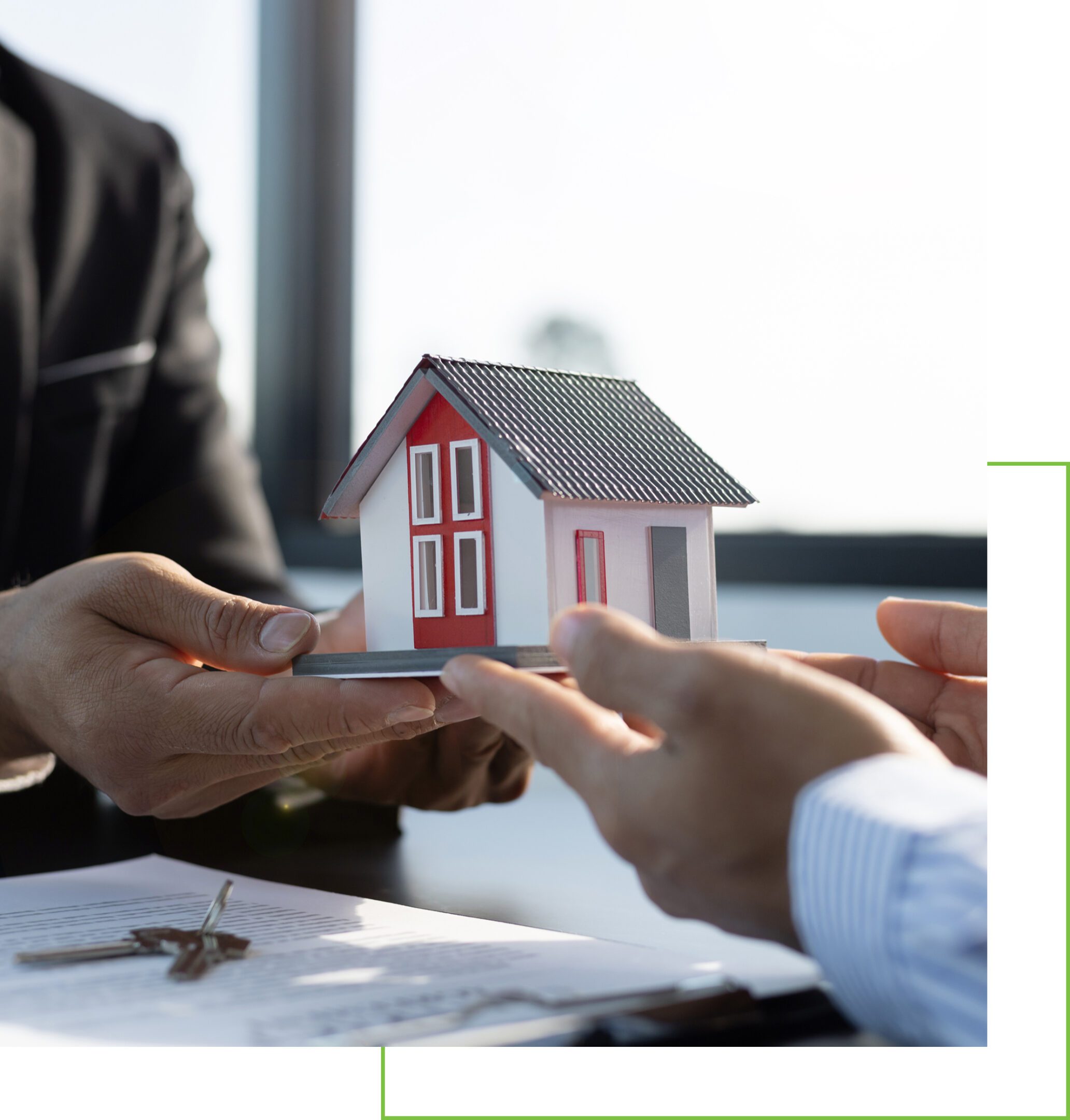 Two people exchanging a small house model symbolizing a real estate deal.