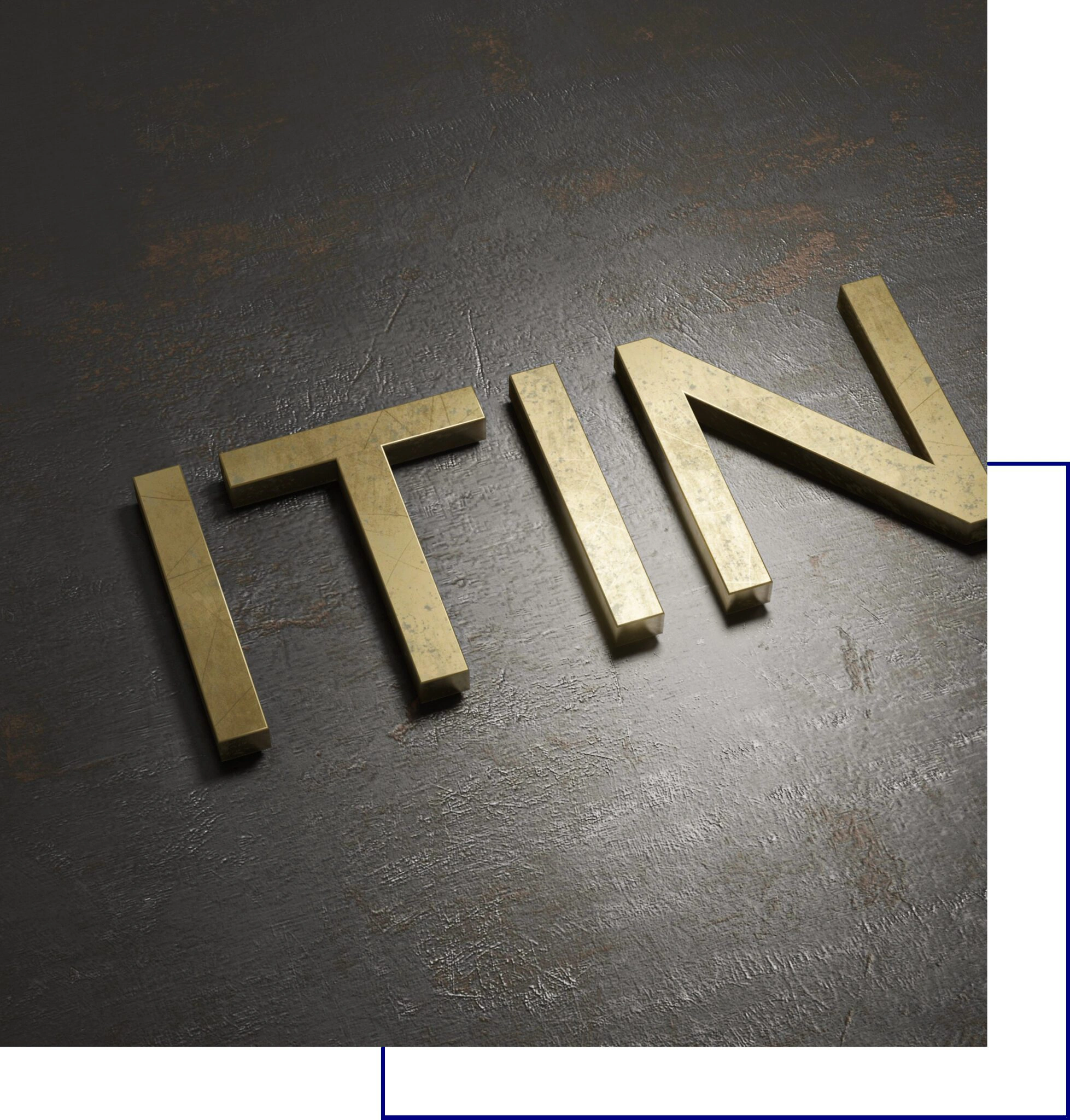 Close-up of gold-colored letters spelling part of a word on a dark surface.