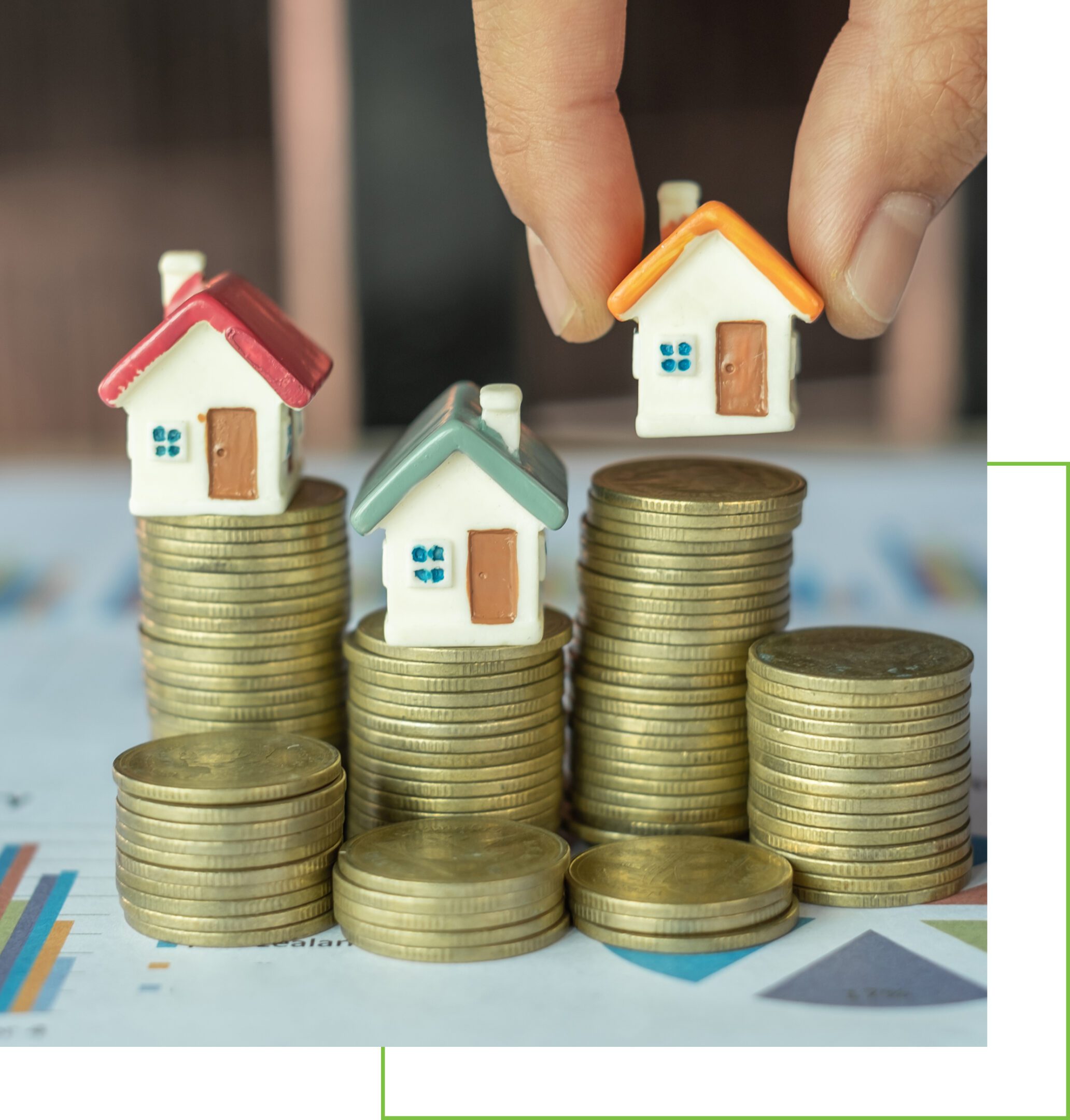 Miniature houses on stacked coins symbolize real estate investment.